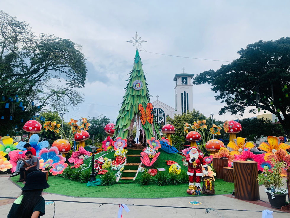 Colorful garden display with Christmas tree and decorations.