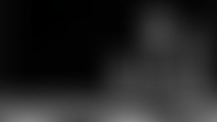 Three clear glass chess pieces on a board against a black background, creating a stark, moody still life. Relating to the game of chess and the strategy of AI governance with token costs.