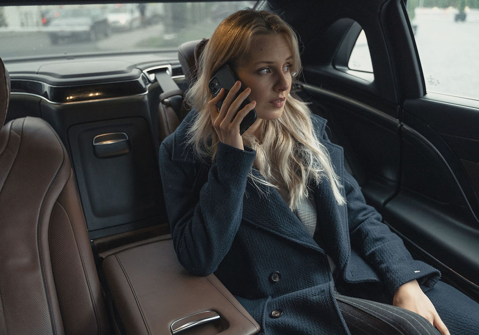 Woman on the phone in luxury chauffeur driven car