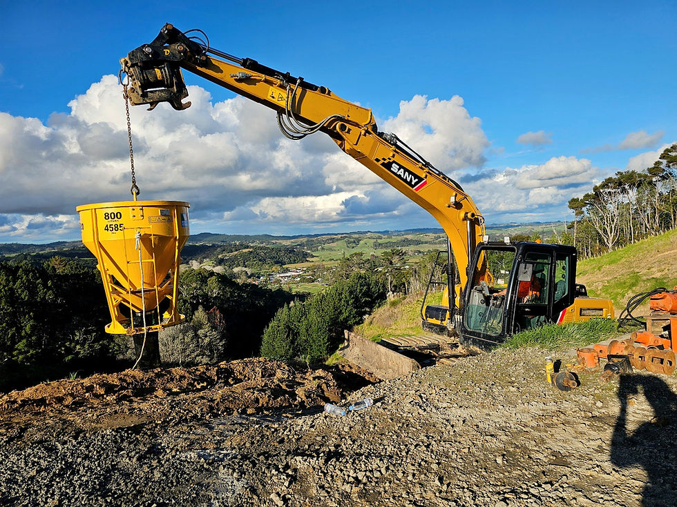 Civil construction excavator placing concrete on a steep Auckland site