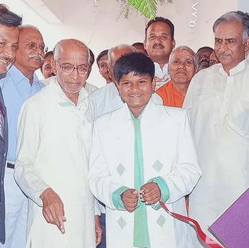 Group of people at an event watching an individual cut a red ribbon
