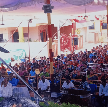 Speaker addressing a large audience at an outdoor event