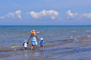 Mother and 2 children walking in the water