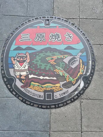 A manhole showing okonomiyaki