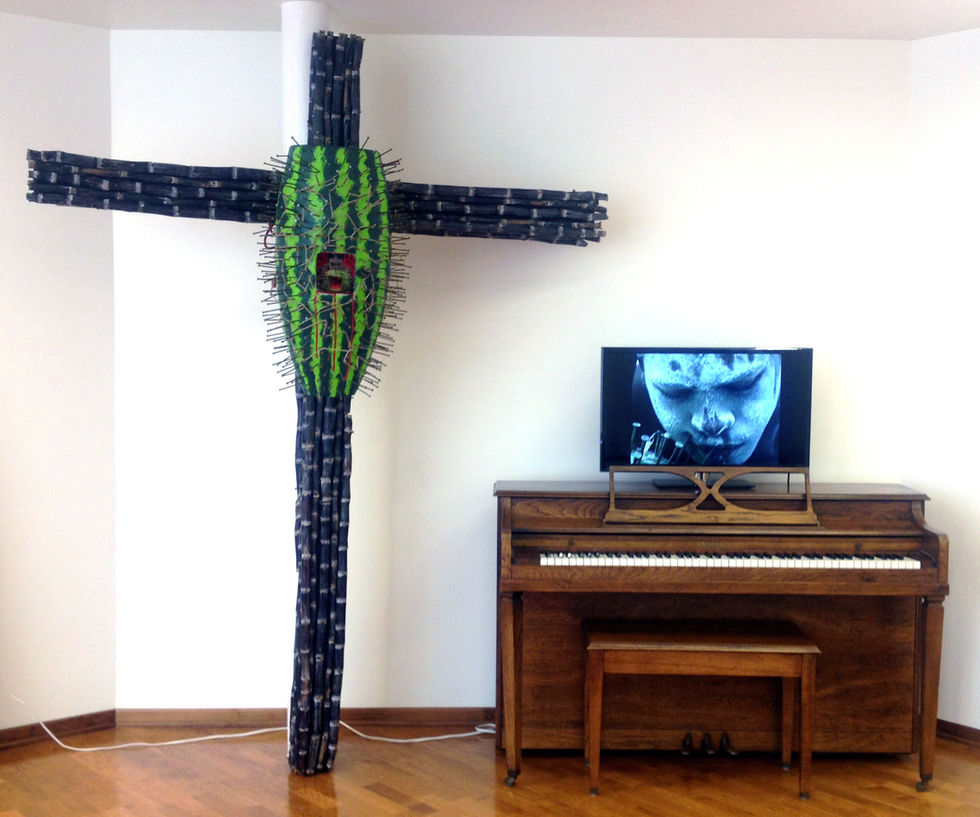 Lili Bernard. Nkisi Crucifix Ain't Funny, 2014. Wood, Conga Drum, Iron Nails, Acrylic Paint, Rope, Sugar Cane, Digital Photo, Watermelon Seed, 96 x 72 x 36 inches and Video Art Installation