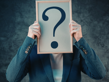 holding question mark over face