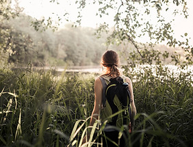 female-hiker-walking-green-grass-near-lake.jpg