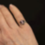 Purple cat's eye ring shown worn on the hand.