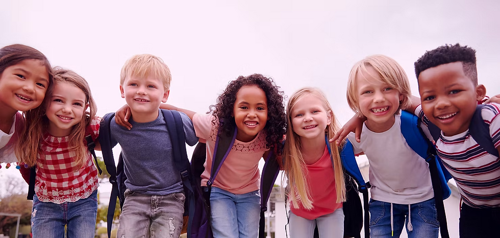 Group of diverse smiling elementary school children standing together outside.