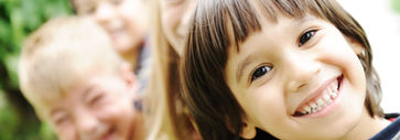 A group of smiling children poses together for the camera, showcasing their joy and friendship.