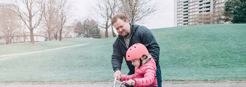Father and Daughters happily cycling together, sharing a moment of joy.