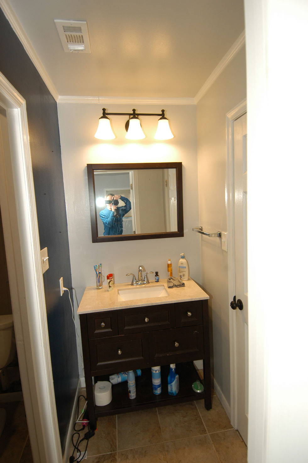 Before photo of bathroom vanity with cultured marble top and center door, wall