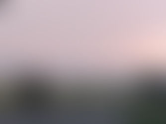 Hazy red skyline from setting sun over lake with fog