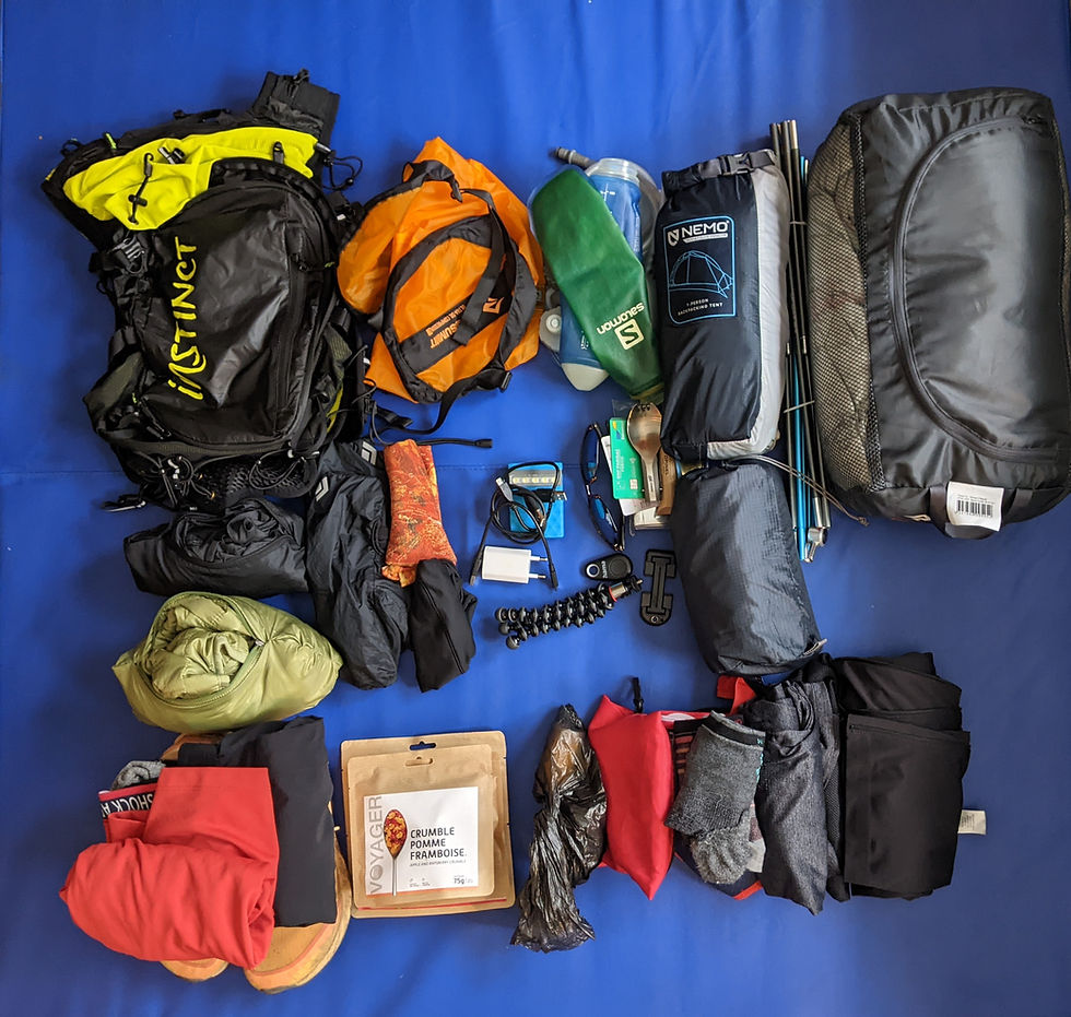 Matériel pour un trail en itinérance présenté sur un tapis bleu
