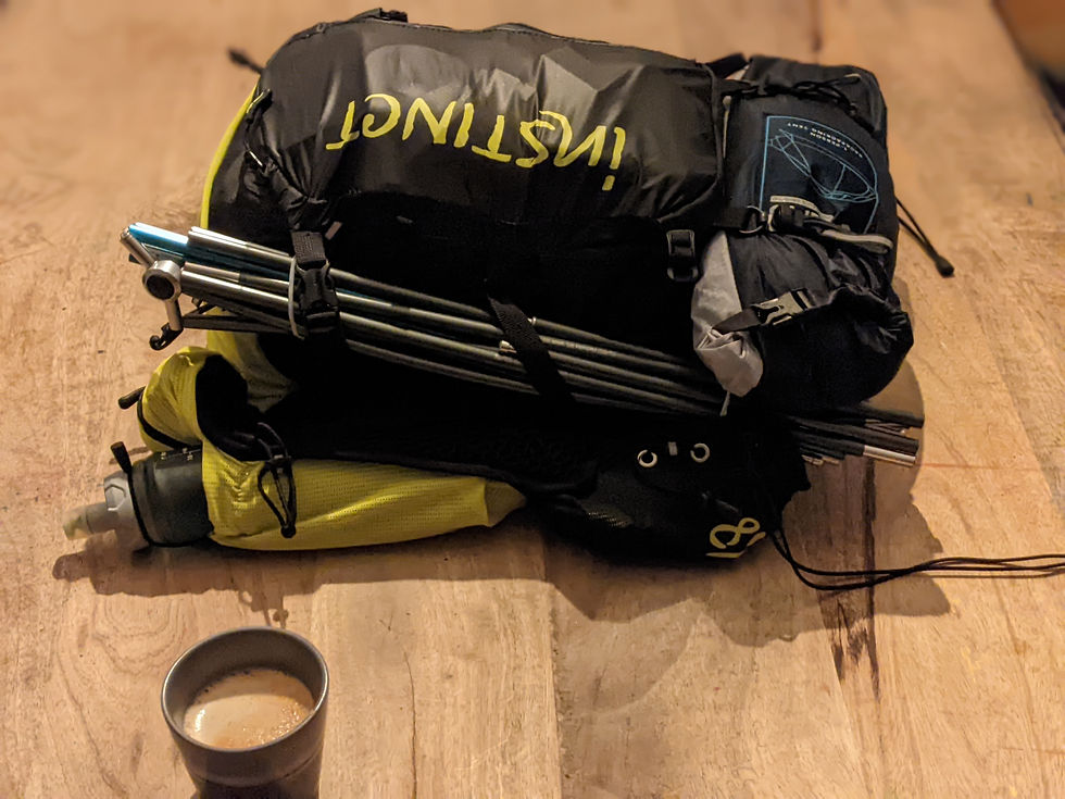 Sac de trail noir et jaune déposé sur une table de bois à côté d'une tasse de café
