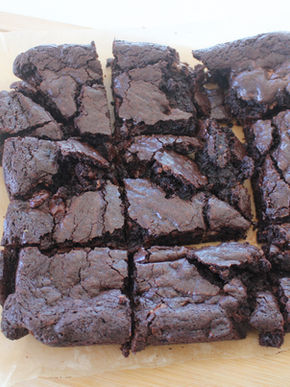 A stack of rich, fudgy chocolate brownies with a gooey center and a crackly top, freshly baked for seasonal treats by Crewneck Chef in Raleigh, NC.