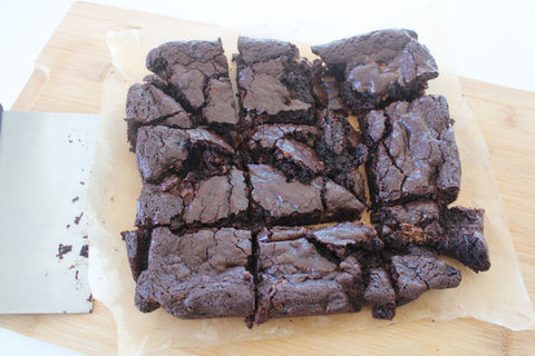 A stack of rich, fudgy chocolate brownies with a gooey center and a crackly top, freshly baked for seasonal treats by Crewneck Chef in Raleigh, NC.
