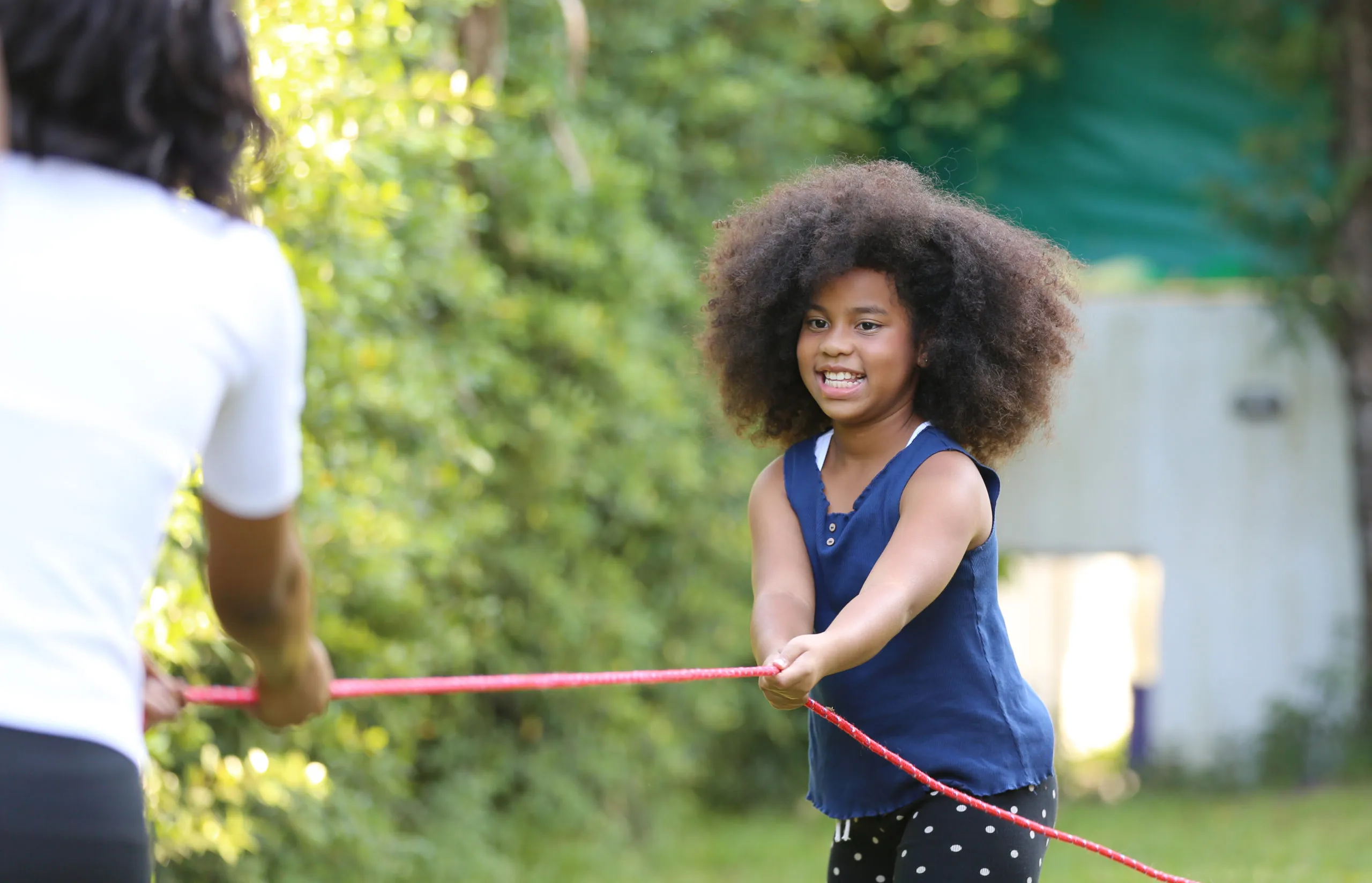Black little girl playing tug of war