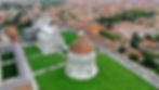 Cathedral of Santa Maria Assunta and Baptistery in Piazza dei Miracoli, Pisa, Tuscany, Italy, Aerial photo from drone. There is pisan houses with orange roofs on the picture.