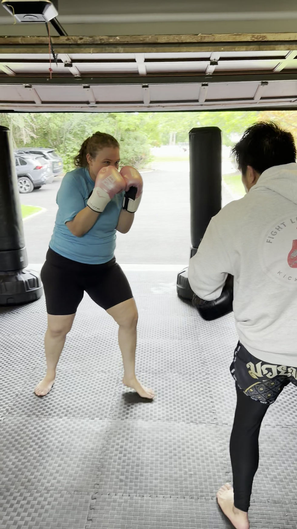 Female client hitting pads during a private kickboxing session with Logan, South Orange, NJ