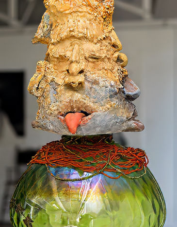 Stacked sculpted faces as immersive installation art.