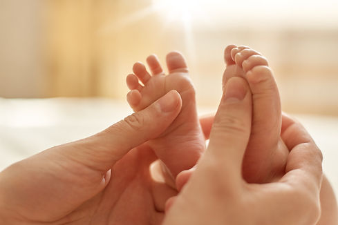 mum-making-baby-massage-mother-massaging-infant-bare-foot-preventive-massage-newborn-mommy