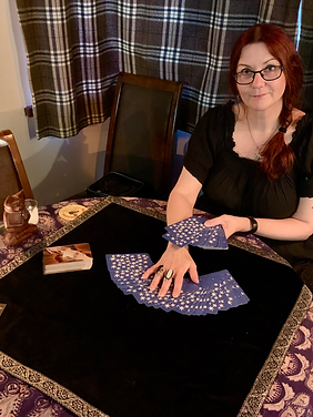 Tarot reader from Wegweiser Tarot sitting at a table with her cards