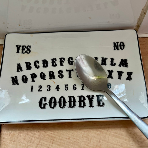 A china spoon rest with black spirit board lettering