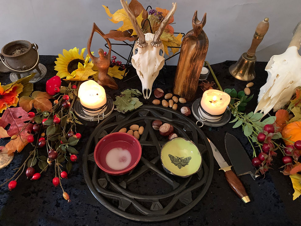 Pagan altar with autumn decorations, god and goddess figures, candles, a deer skull and ritual tools