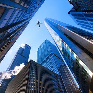 Downtown Chicago commercial office towers viewed from below against a blue sky.