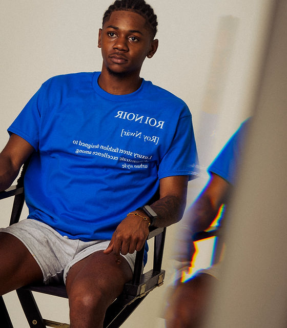 Shawn Jackson, founder of Roi Noir, seated wearing a blue outfit