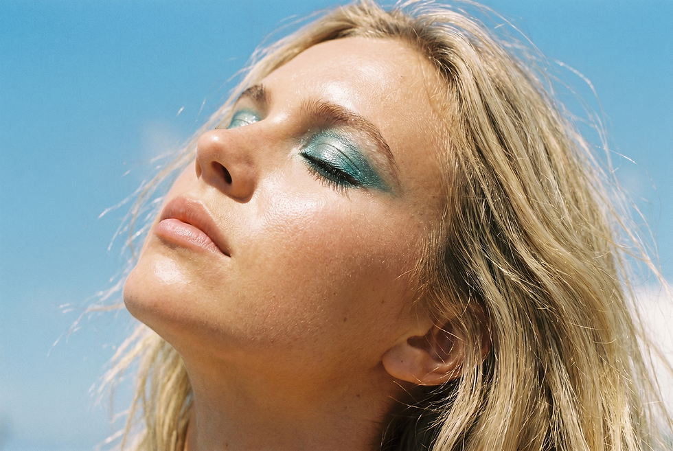 Generated with Kive.ai - Young blonde woman_ face tilted upward toward open sky_ bold teal