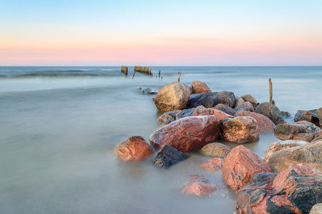 Old pierce. Baltic sea. Stones. Dusk. Afterglow. Long exposure.
