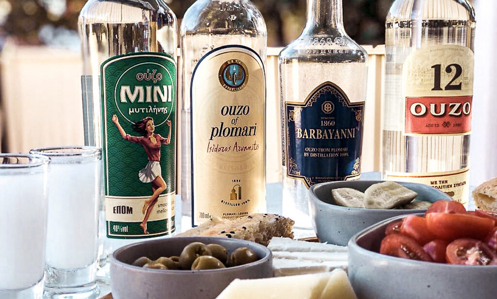 4 bottles of Ouzo on a table of snacks