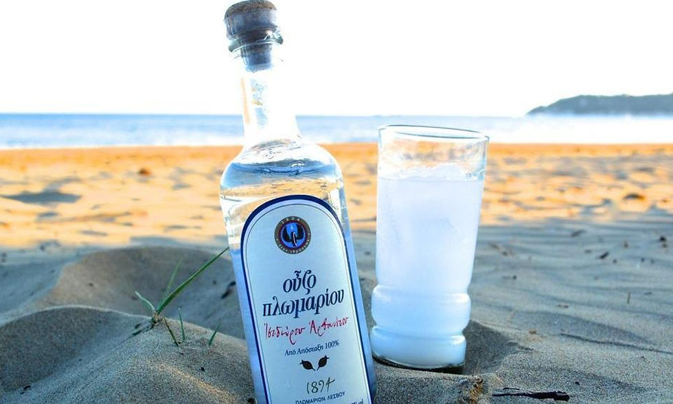 Bottle of ouzo and glass of ouzo on the beach