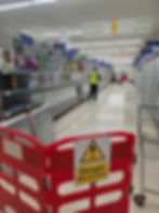 Staff working in a grocery store gallery freezer aisle.