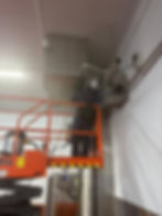 Technician on a lift repairing HVAC unit for gallery
