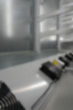Industrial cooling fans mounted on metal racks in the gallery.