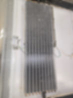 Close-up of refrigerator evaporator coils in a gallery