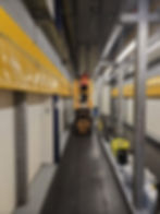 Worker on a scissor lift in a warehouse gallery
