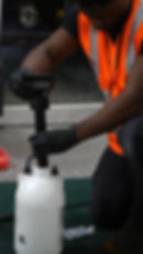 Worker using a spray pump in a gallery setting.