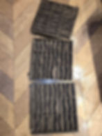 Three dirty air filters on a floor gallery