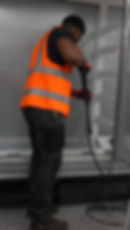 Worker in safety vest cleaning a commercial glass gallery
