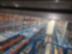 High-angle view of a warehouse gallery with blue pallets.