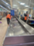 Staff cleaning a large stainless steel fish gallery counter.