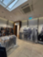 Modern clothing gallery with items covered in plastic.