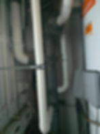 Plumbing pipes and water heater in gallery