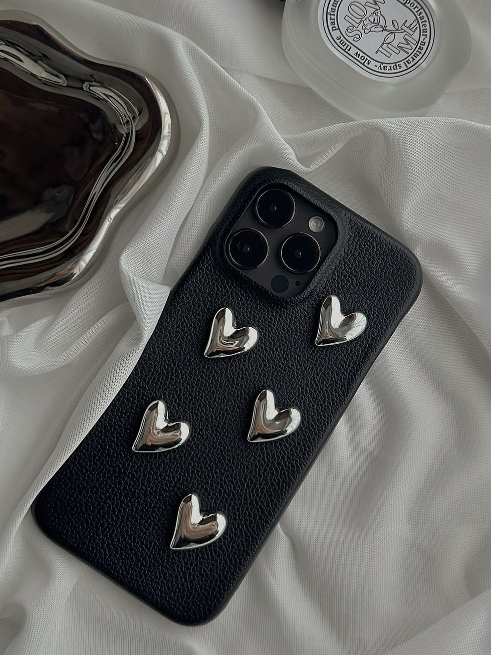 Cute black iPhone 14 case with silver heart accents. Perfect for adding a touch of girly charm to your phone.