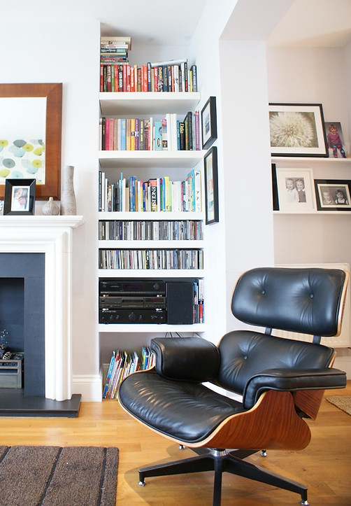 bespoke shelving, limestone fireplace and eames chair