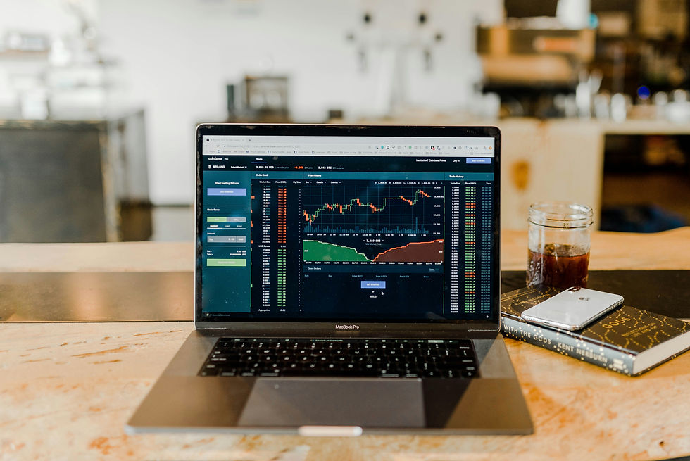 Laptop displaying stock market charts and financial trading data.